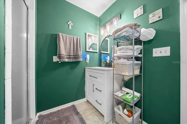 a bed room with a bed a dresser and a chandelier