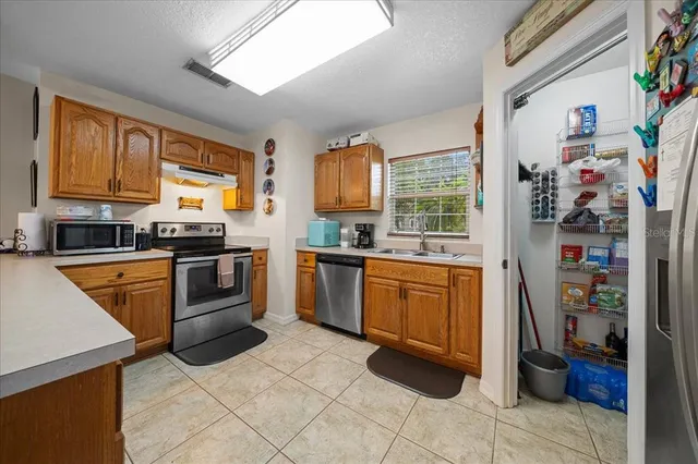 a kitchen with stainless steel appliances granite countertop a stove sink and cabinets