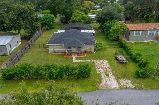 an aerial view of a house with swimming pool patio and lake view