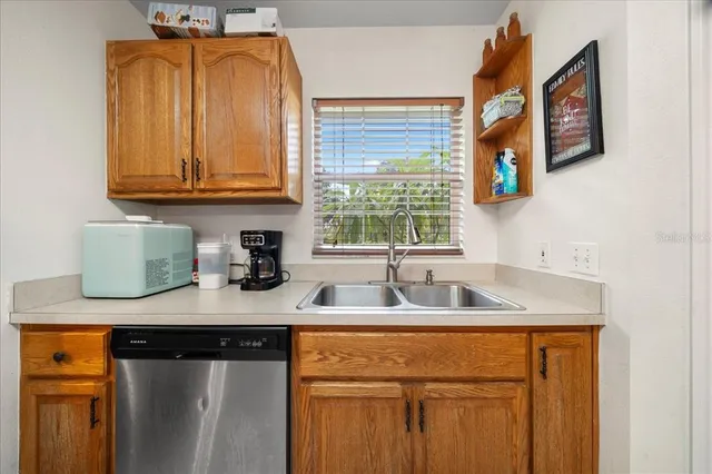 a spacious kitchen with stainless steel appliances granite countertop a sink and dishwasher with white cabinets