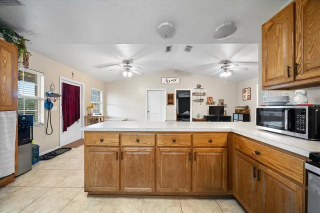 a kitchen with stainless steel appliances granite countertop a refrigerator a stove top oven a sink dishwasher and wooden cabinets with a large window