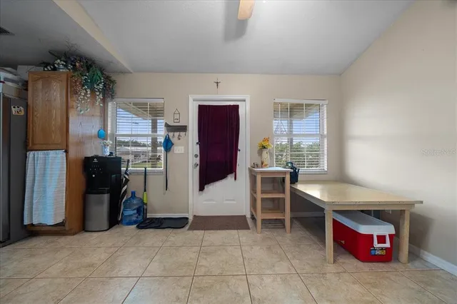 a kitchen with stainless steel appliances kitchen island granite countertop dining table chair and a refrigerator
