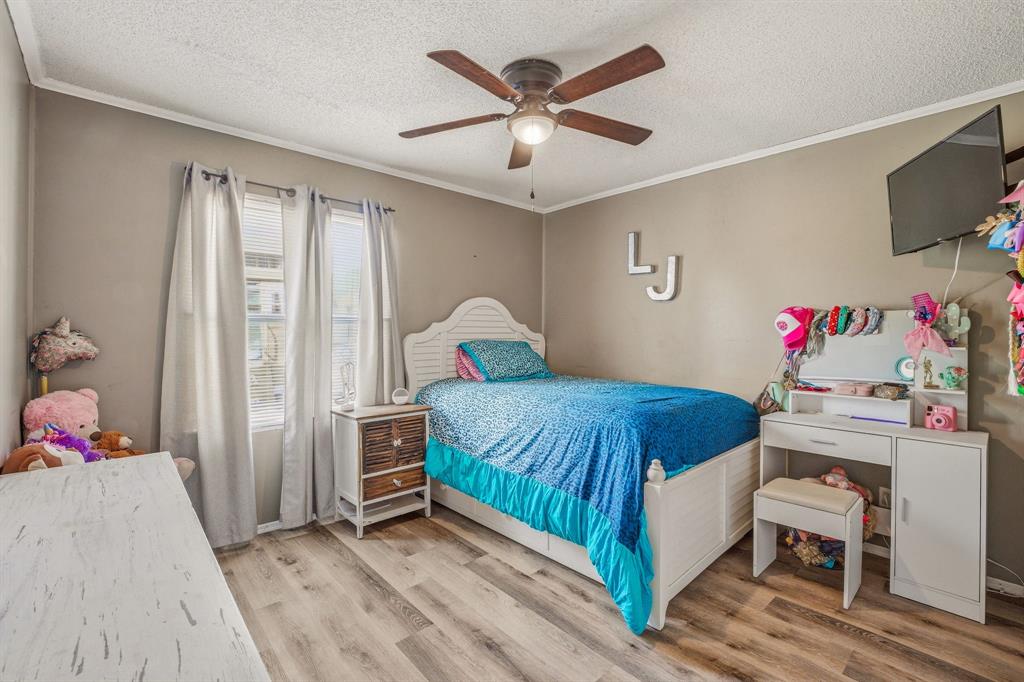 151 High Point Road Weatherford, TX 76088 - Photo 16 of 40 a bedroom with a bed and a chandelier