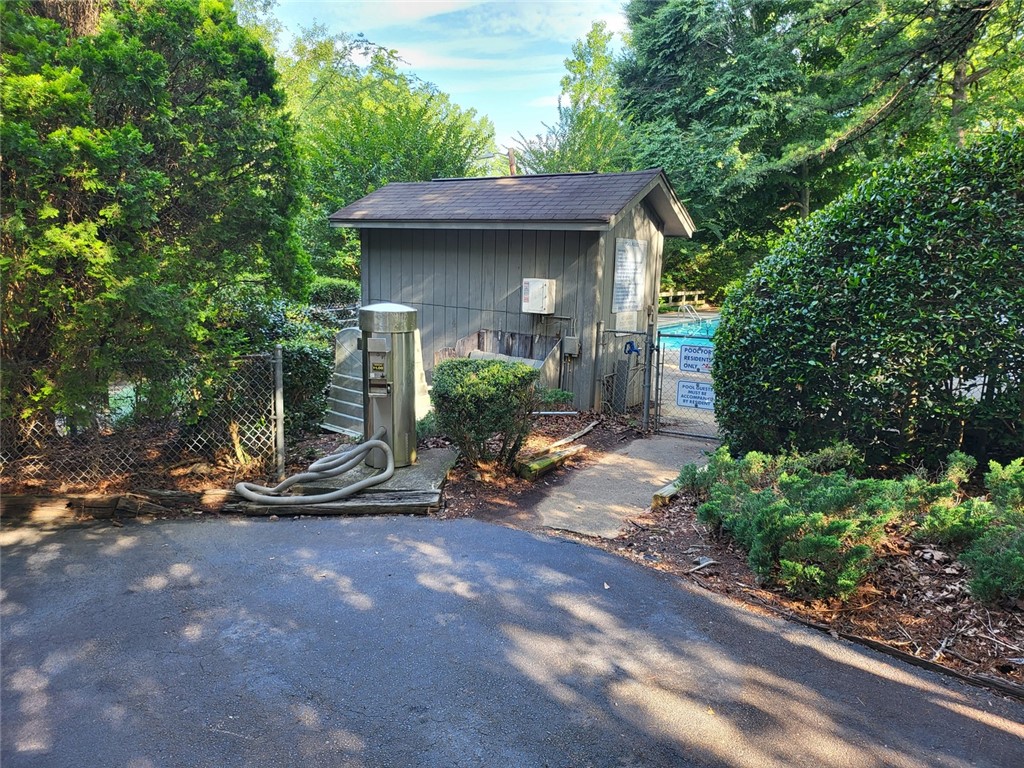 150 Ligon Street, Unit 1001 Clemson, SC 29631 - Photo 24 of 29 A private pool area beckons through a gated fence, surrounded by lush, mature greenery.