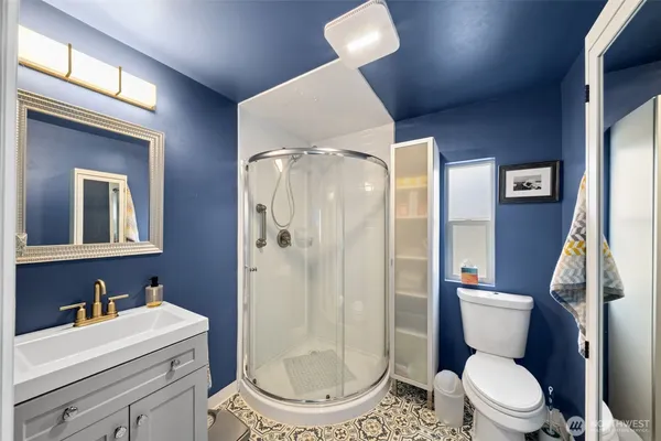 a bathroom with a granite countertop toilet sink and mirror