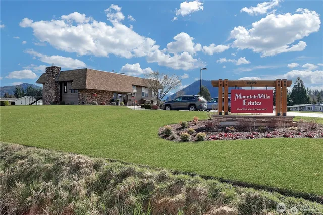 a view of a sign in front of house with yard