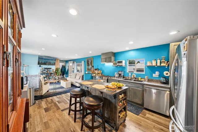 a kitchen with stainless steel appliances a table and chairs