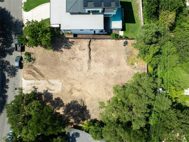 an aerial view of a house with a yard and trees