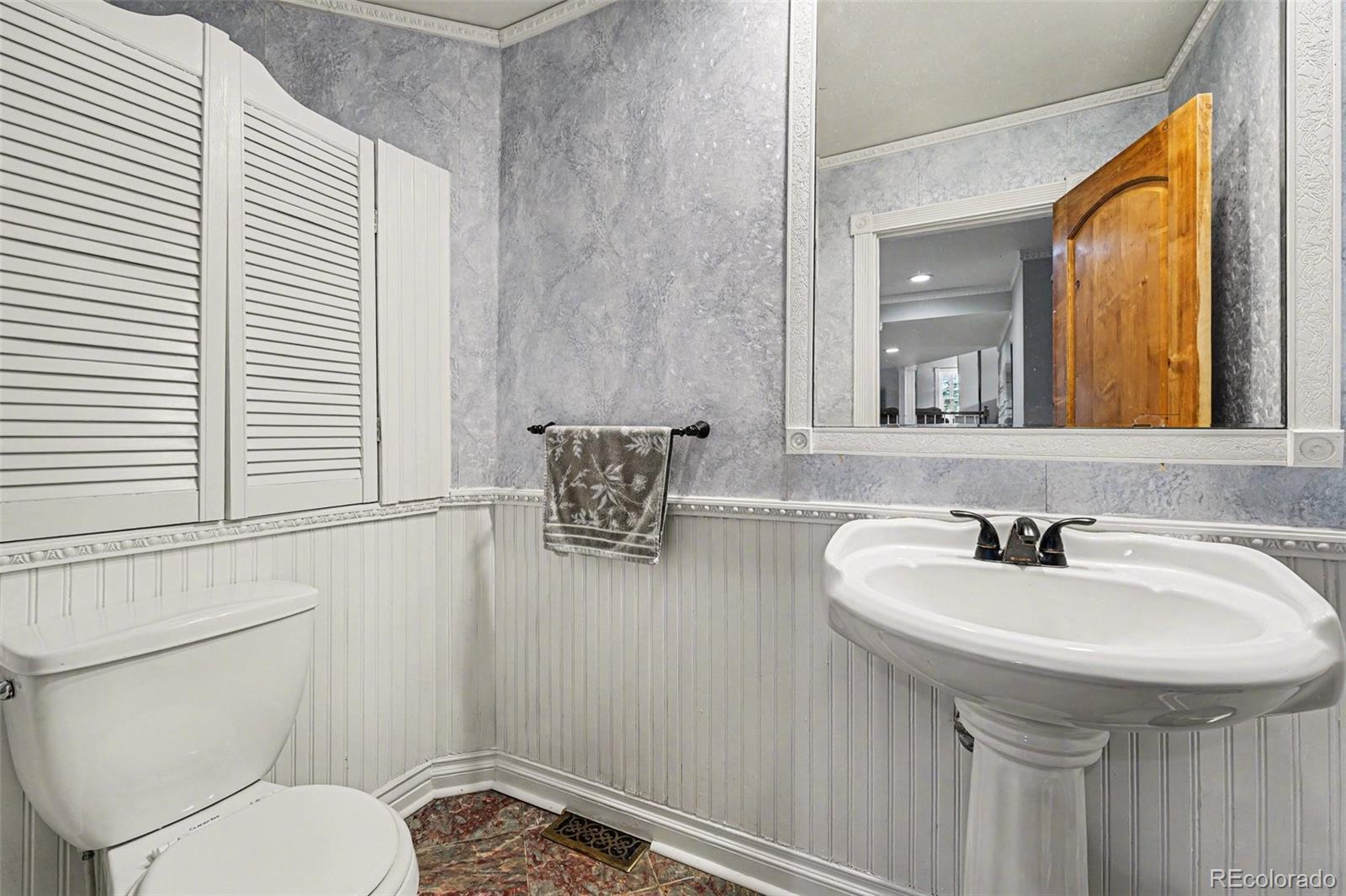6650 North Village Road Parker, CO 80134 - Photo 11 of 46 a bathroom with a toilet a sink and a mirror