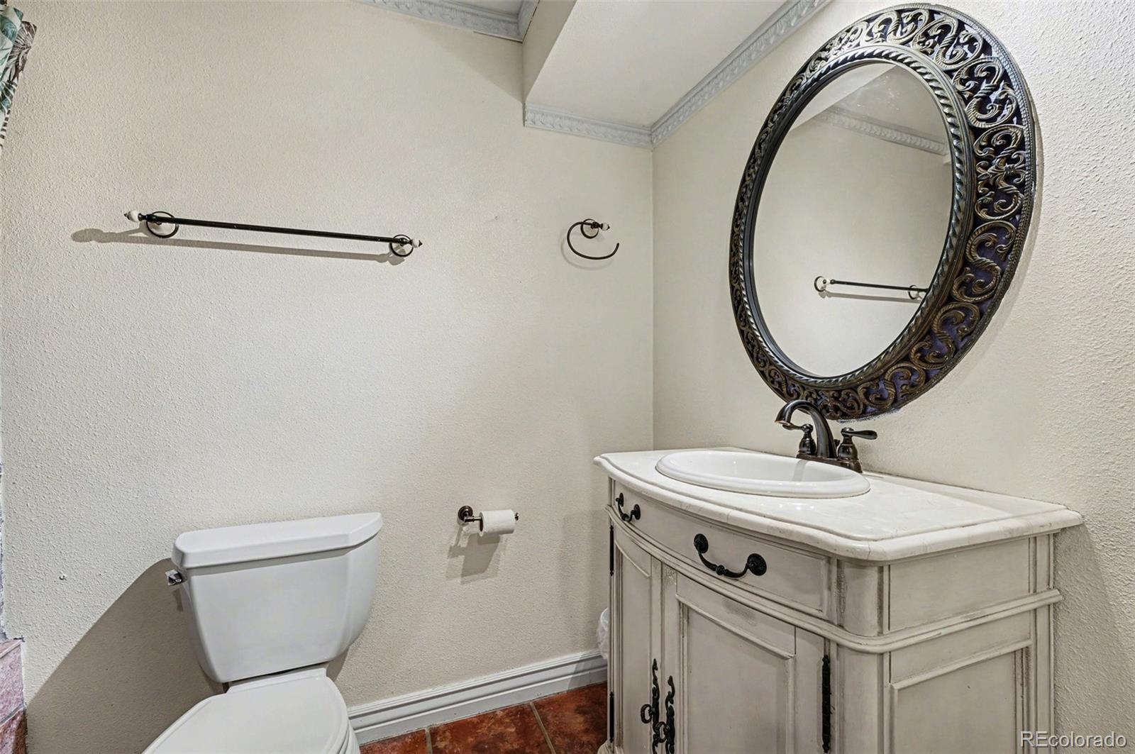 6650 North Village Road Parker, CO 80134 - Photo 35 of 46 a bathroom with a sink mirror vanity and toilet