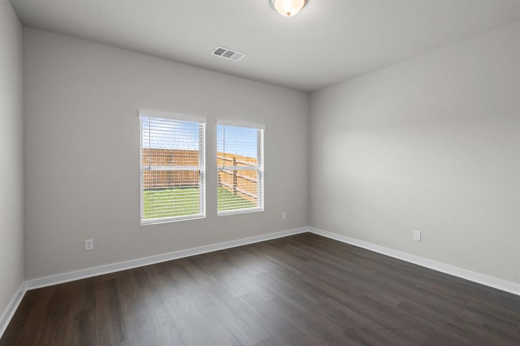 177 Sleep Hollow Jarrell, TX 76537 - Photo 14 of 24 Room featuring two windows with blinds, wood-finish flooring, white baseboards, and a flush-mount ceiling light