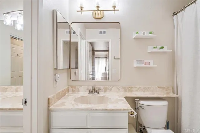 a bathroom with a sink a toilet and mirror