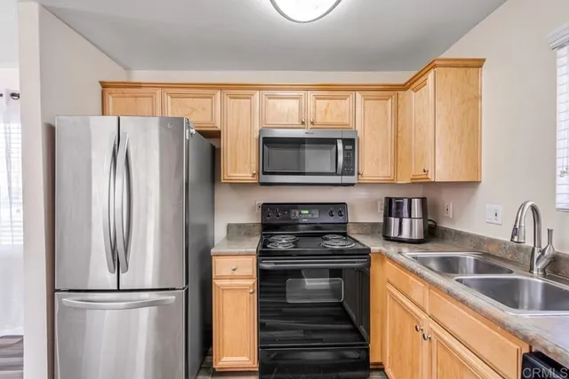 a kitchen with granite countertop a refrigerator stove and microwave