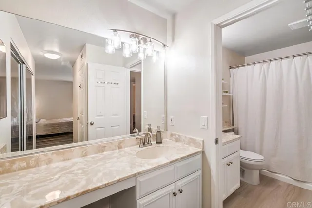 a bathroom with a granite countertop sink toilet and shower
