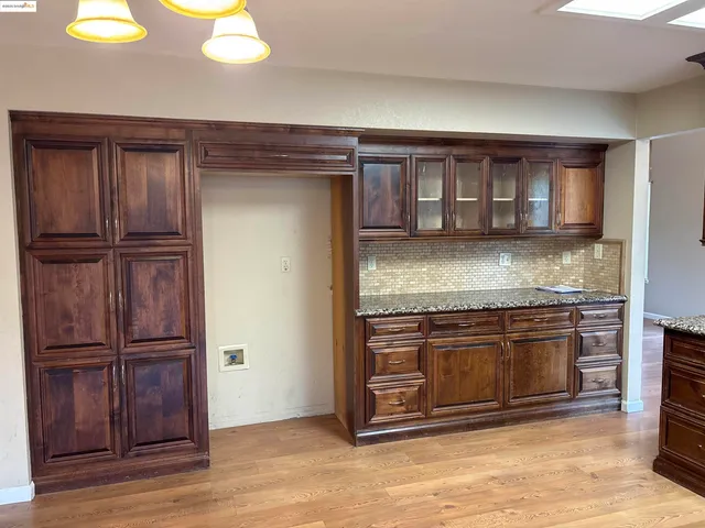a kitchen with granite countertop wooden cabinets and stainless steel appliances