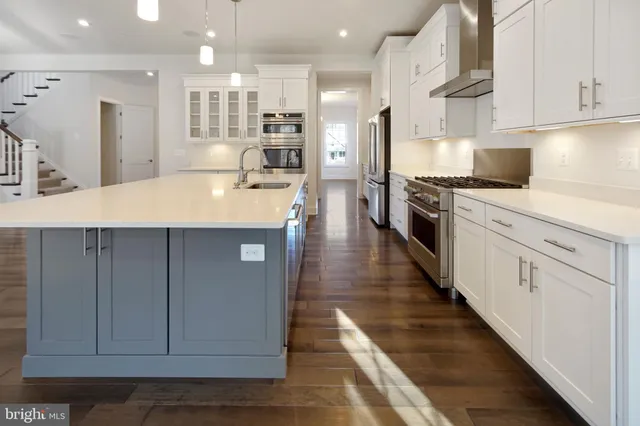 a kitchen with stainless steel appliances kitchen island granite countertop a stove a sink and a refrigerator