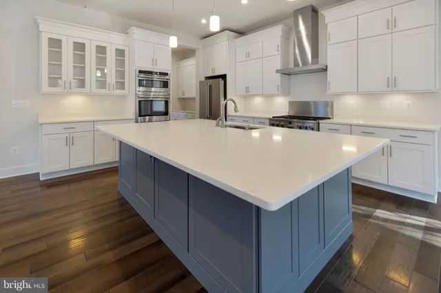 a kitchen with stainless steel appliances a white stove top oven and white cabinets
