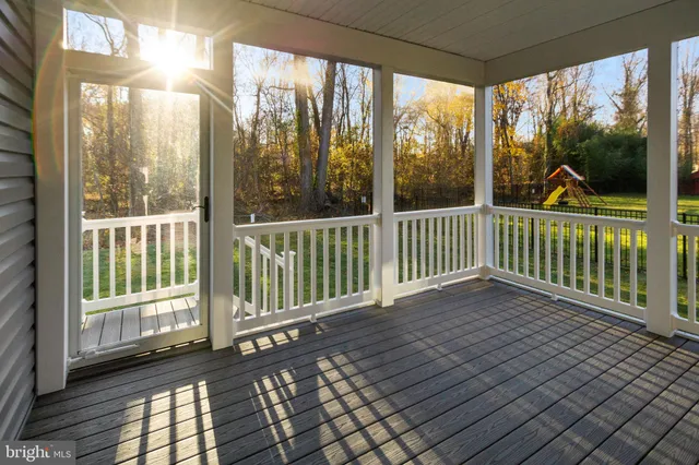 a view of a porch with wooden floor and floor to ceiling window