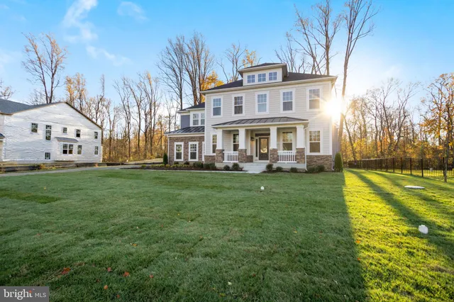 a front view of a house with garden and trees