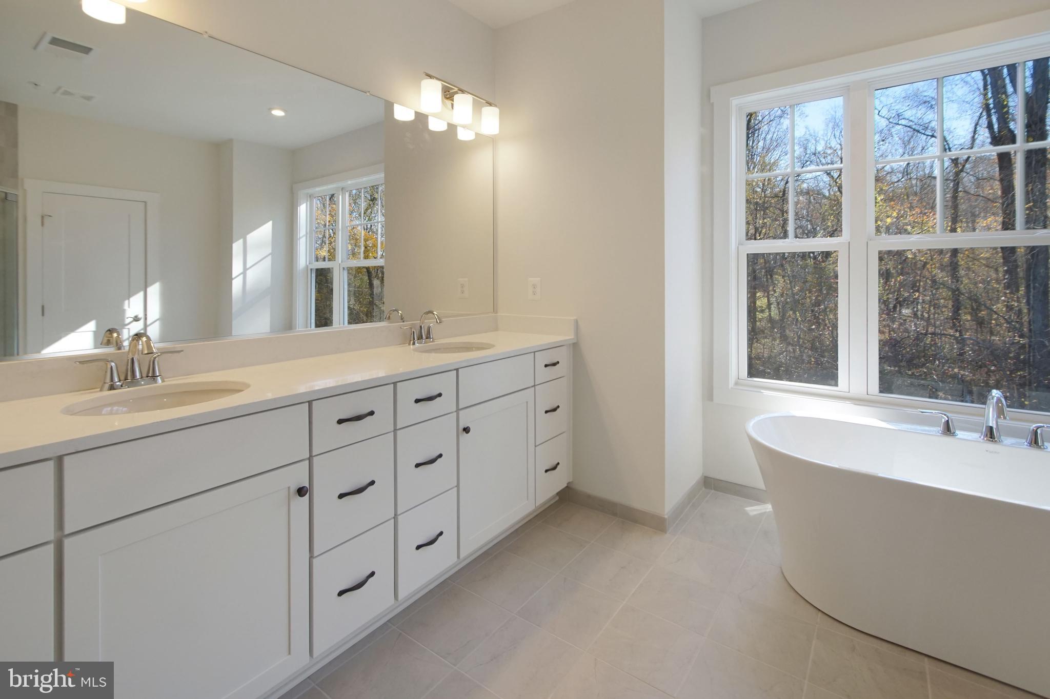 7 Copperleaf Boulevard Hanover, MD 21076 - Photo 33 of 46 a spacious en suite bathroom with a double vanity sink a large mirror and a bathtub