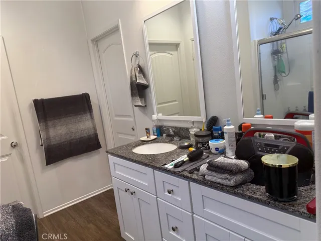 a bathroom with a granite countertop double vanity and a mirror