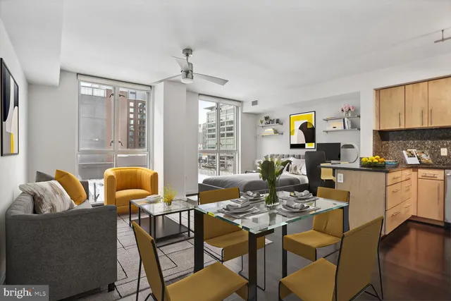 a living room with furniture kitchen view and a window