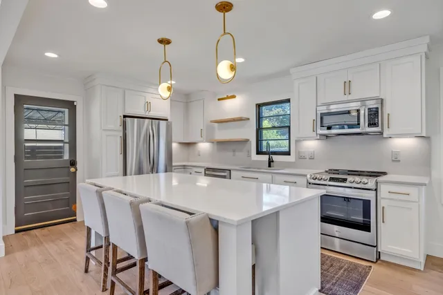 a kitchen with stainless steel appliances granite countertop a stove a sink and a refrigerator