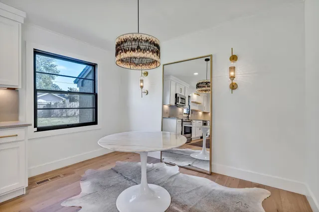 a view of a livingroom and dining room with furniture wooden floor and a chandelier