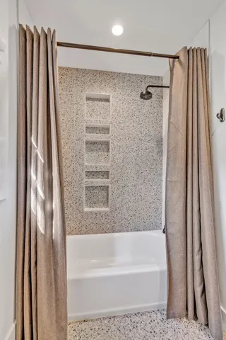 a bathroom with a shower curtain and a tub