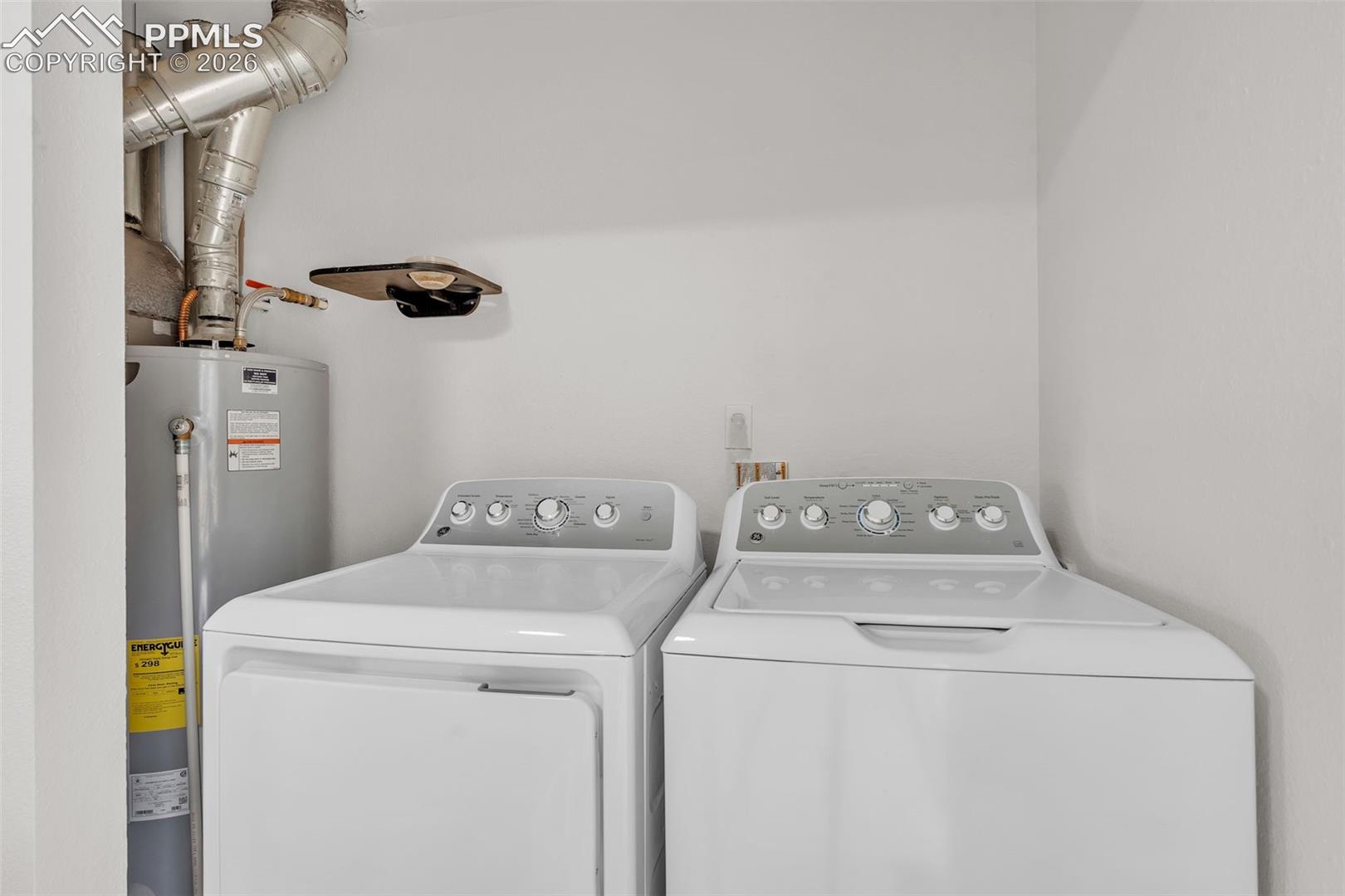 1498 Peterson Road Colorado Springs, CO 80915 - Photo 33 of 44 Laundry room featuring water heater and washing machine and dryer
