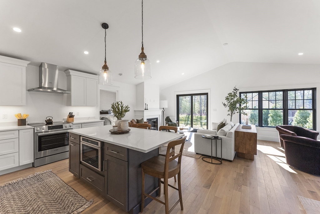 a kitchen with stainless steel appliances granite countertop a stove and a wooden floors