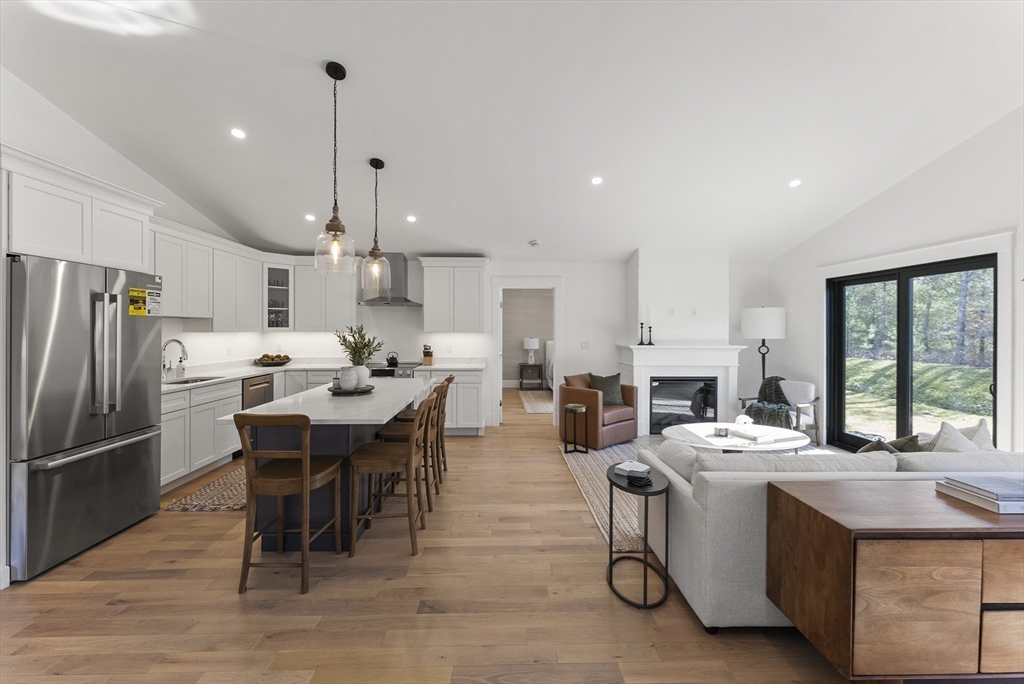 46 Sandwich Road, Unit 41 Plymouth, MA 02360 - Photo 17 of 42 a kitchen with stainless steel appliances kitchen island granite countertop a table chairs sink refrigerator and microwave
