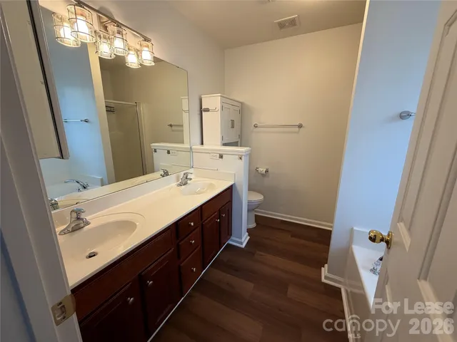 a spacious bathroom with a double vanity sink mirror and toilet