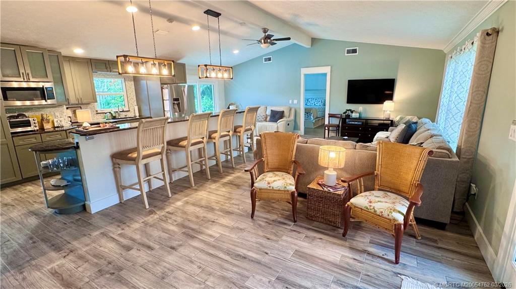 323 Southwest Ridge Lane Stuart, FL 34994 - Photo 2 of 22 a living room with furniture a flat screen tv and kitchen view