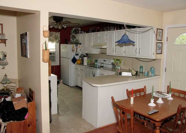 87 Strickland Road Cos Cob, CT 06807 - Photo 3 of 5 a kitchen with stainless steel appliances a table and chairs
