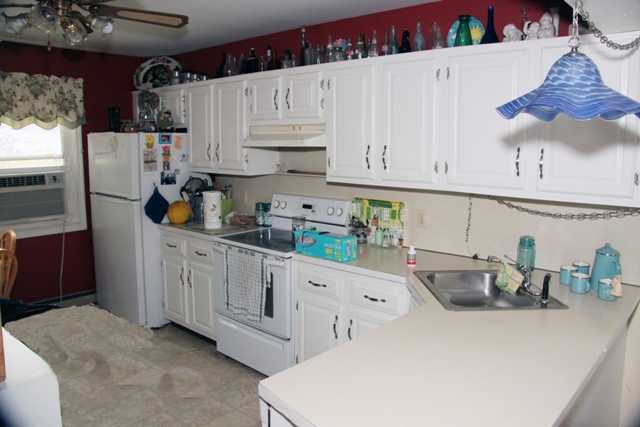 87 Strickland Road Cos Cob, CT 06807 - Photo 4 of 5 a kitchen with stainless steel appliances white cabinets and wooden floors