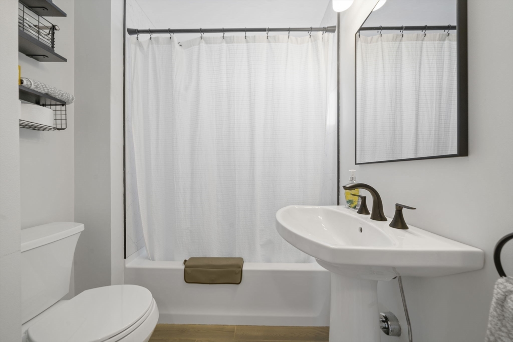 7 Rainbow Terrace Danvers, MA 01923 - Photo 20 of 33 a bathroom with a sink a toilet and shower curtain