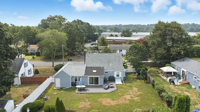 an aerial view of a house with swimming pool and yard