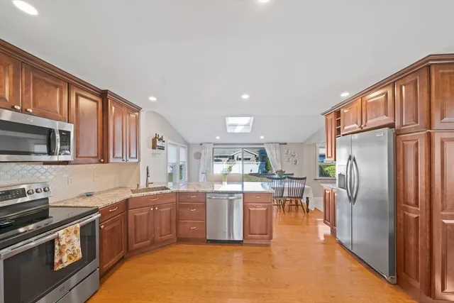 a kitchen with stainless steel appliances granite countertop a refrigerator a stove top oven a sink and dishwasher