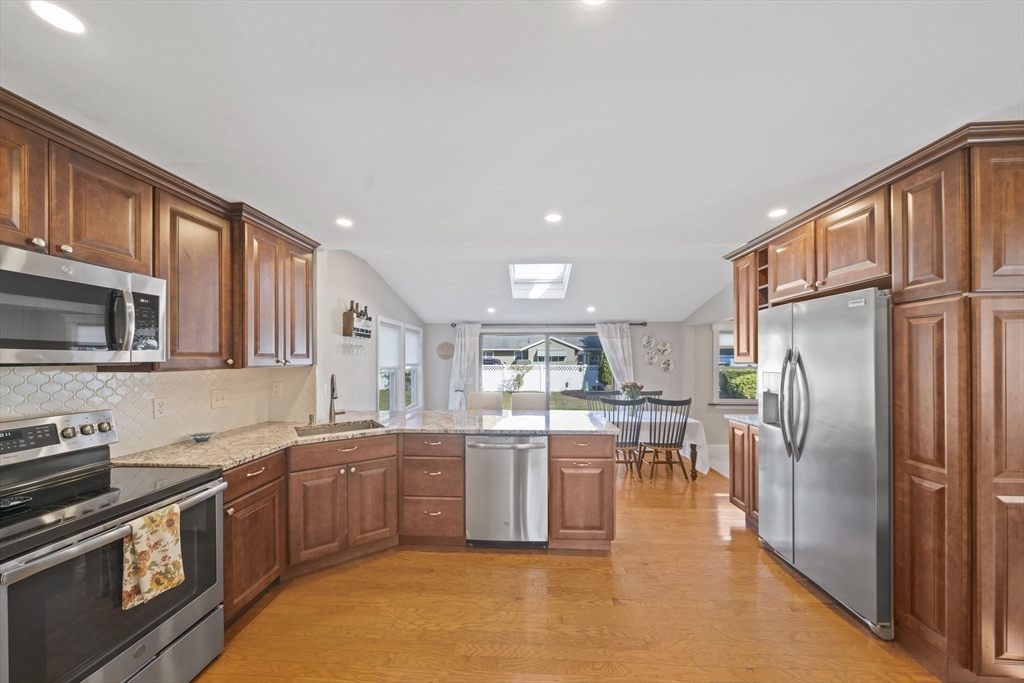7 Rainbow Terrace Danvers, MA 01923 - Photo 7 of 33 a kitchen with stainless steel appliances granite countertop a refrigerator a stove top oven a sink and dishwasher