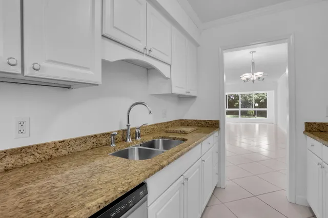 a kitchen with granite countertop white cabinets and a sink