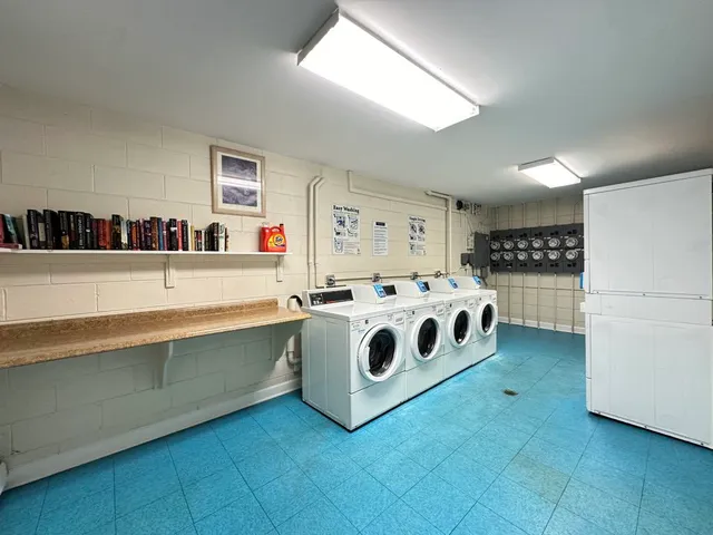 a white kitchen with stainless steel appliances a white stove top oven and a refrigerator