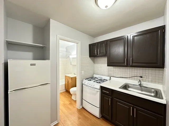 a white kitchen with a sink stainless steel appliances and refrigerator
