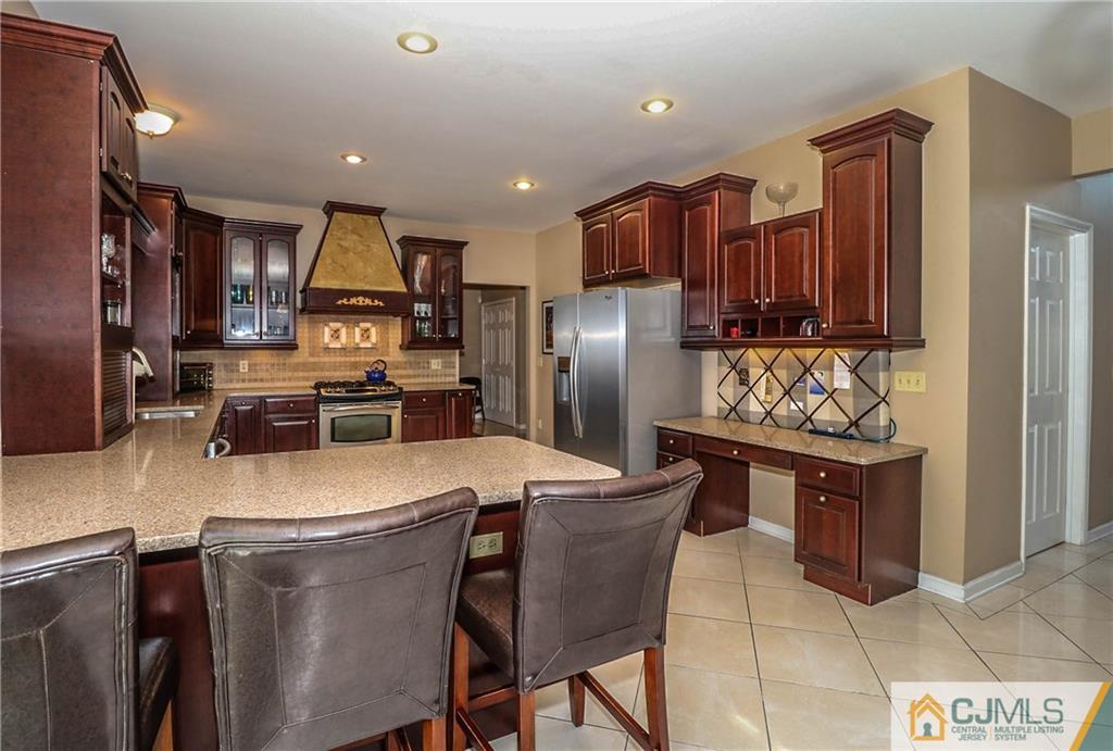 1115 New Dover Road Edison, NJ 08820 - Photo 8 of 25 a kitchen with stainless steel appliances granite countertop a refrigerator a stove a sink a dining table and chairs