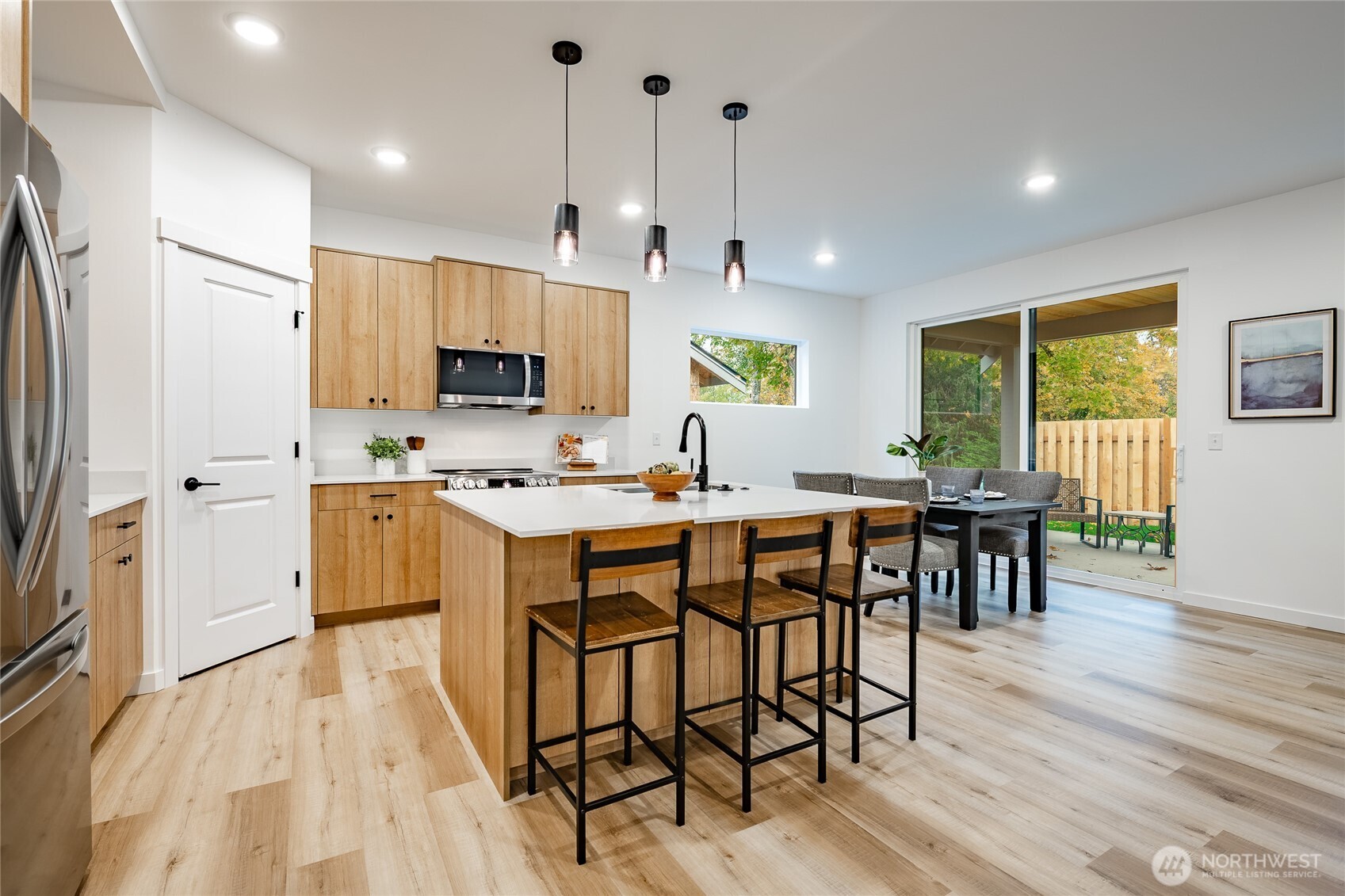 2986 Cedar View Road Blaine, WA 98230 - Photo 18 of 40 a kitchen with stainless steel appliances granite countertop a stove a refrigerator a microwave a dining table and chairs with wooden floor