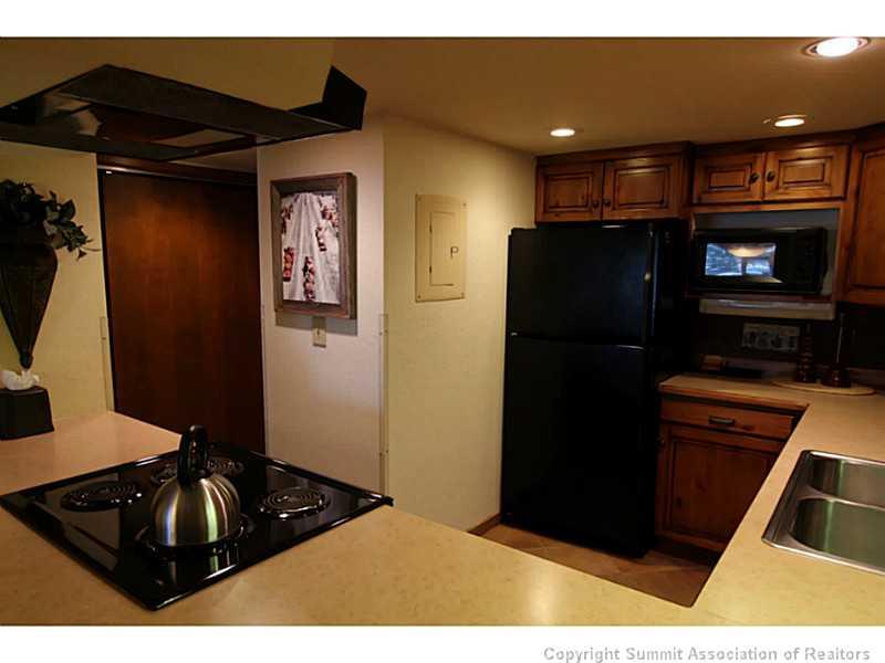 800 Copper Road, Unit 179 Copper Mountain, CO 80443 - Photo 7 of 23 a black refrigerator freezer sitting in a kitchen