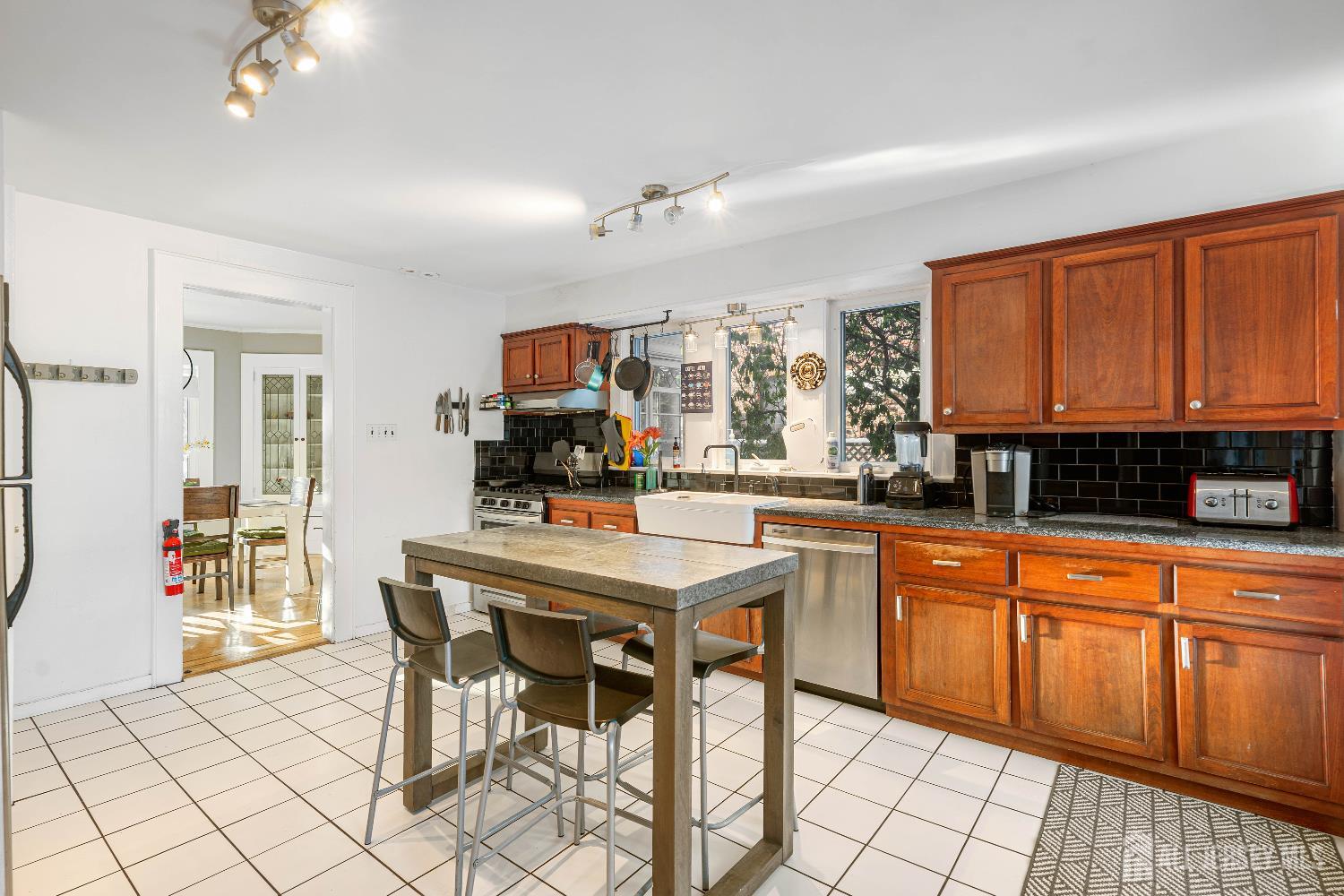 631 Union Avenue Elizabeth, NJ 07208 - Photo 12 of 30 a kitchen with stainless steel appliances granite countertop a stove top oven a sink a dining table and chairs with wooden floor