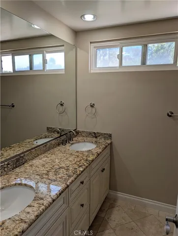 a bathroom with a granite countertop sink and a mirror