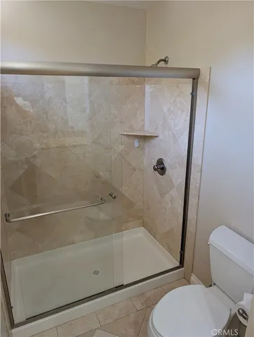 a bathroom with a toilet and a shower