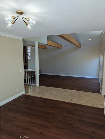 a view of wooden floor and a chandelier fan in a room